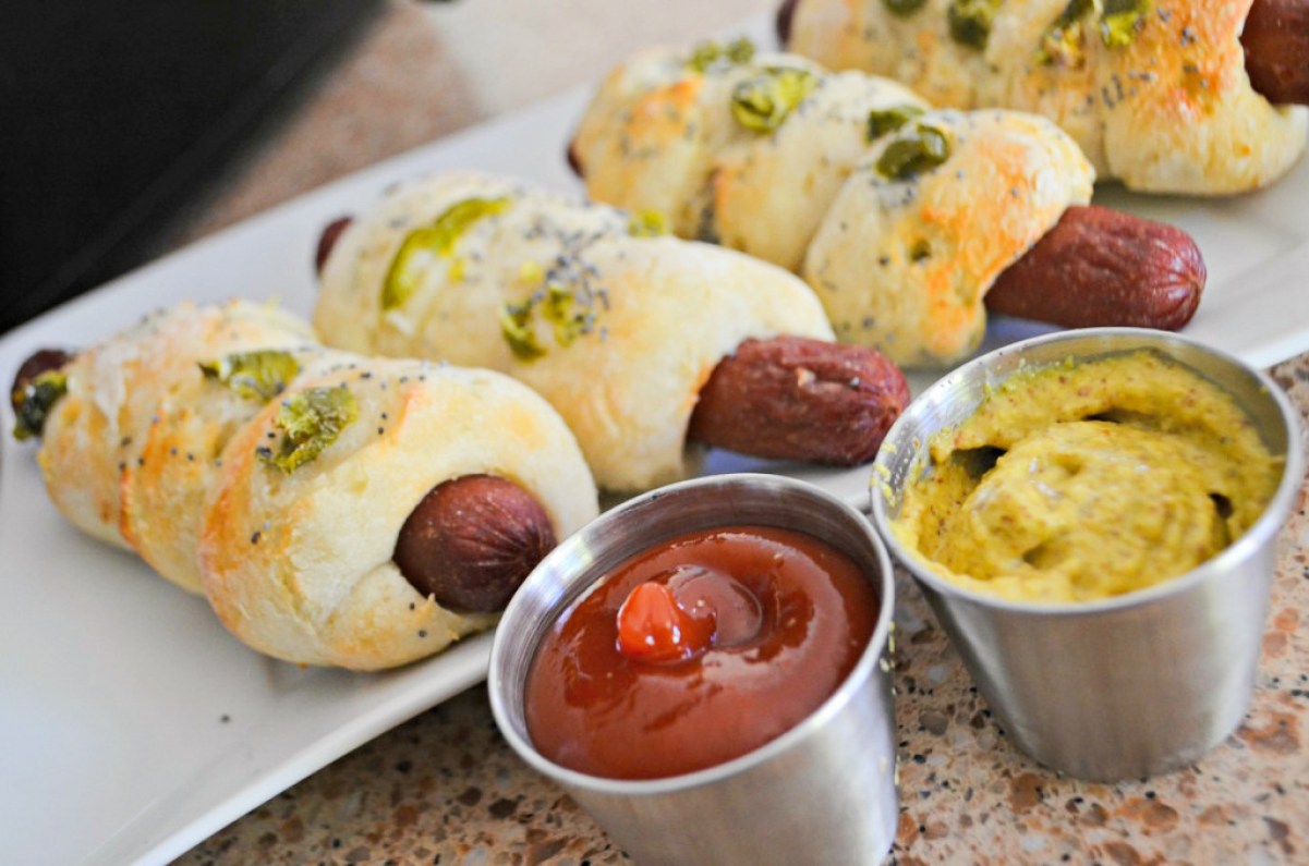 bagel dogs next to condiments for dipping