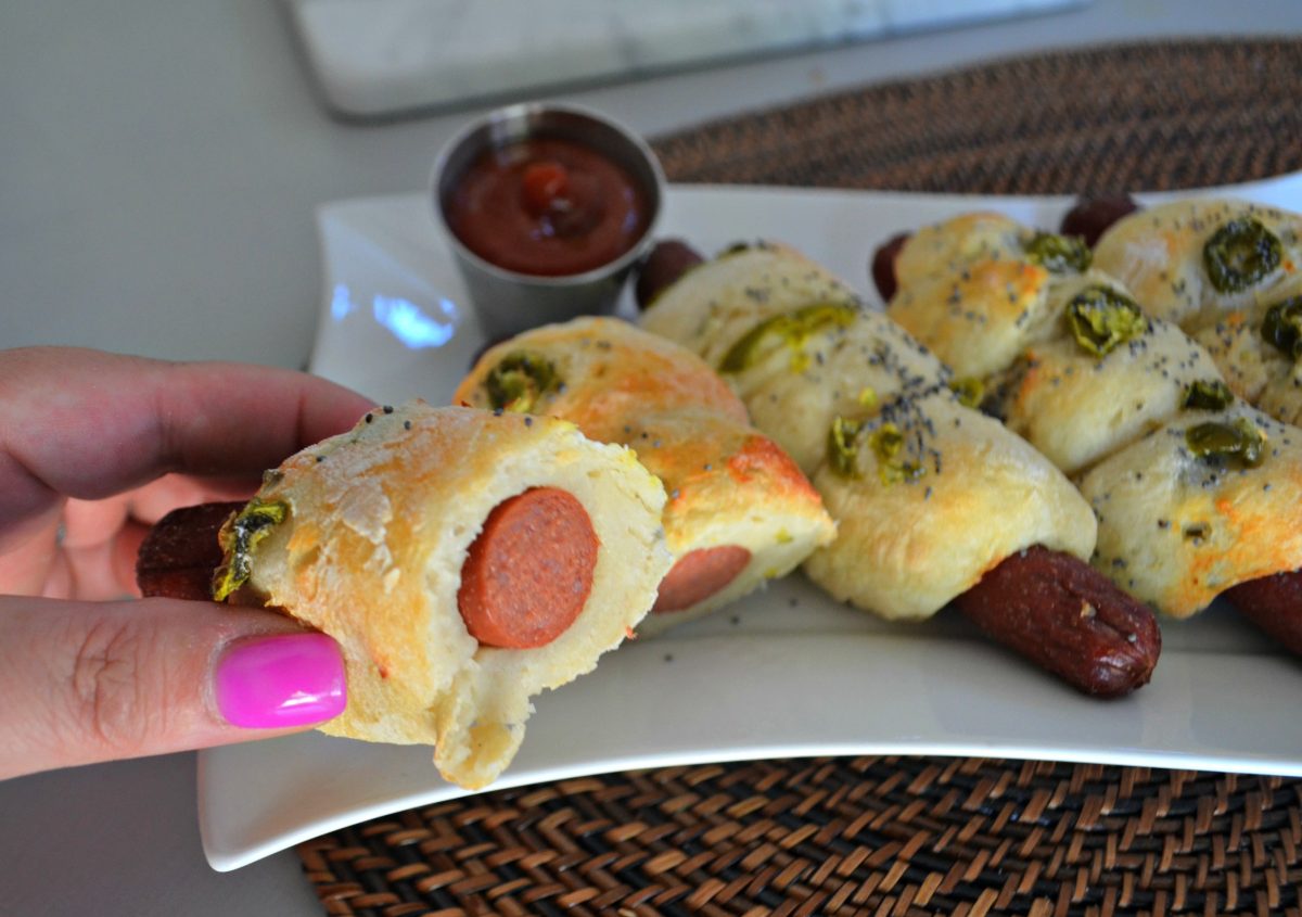 holding a bagel dog that has been cut in half