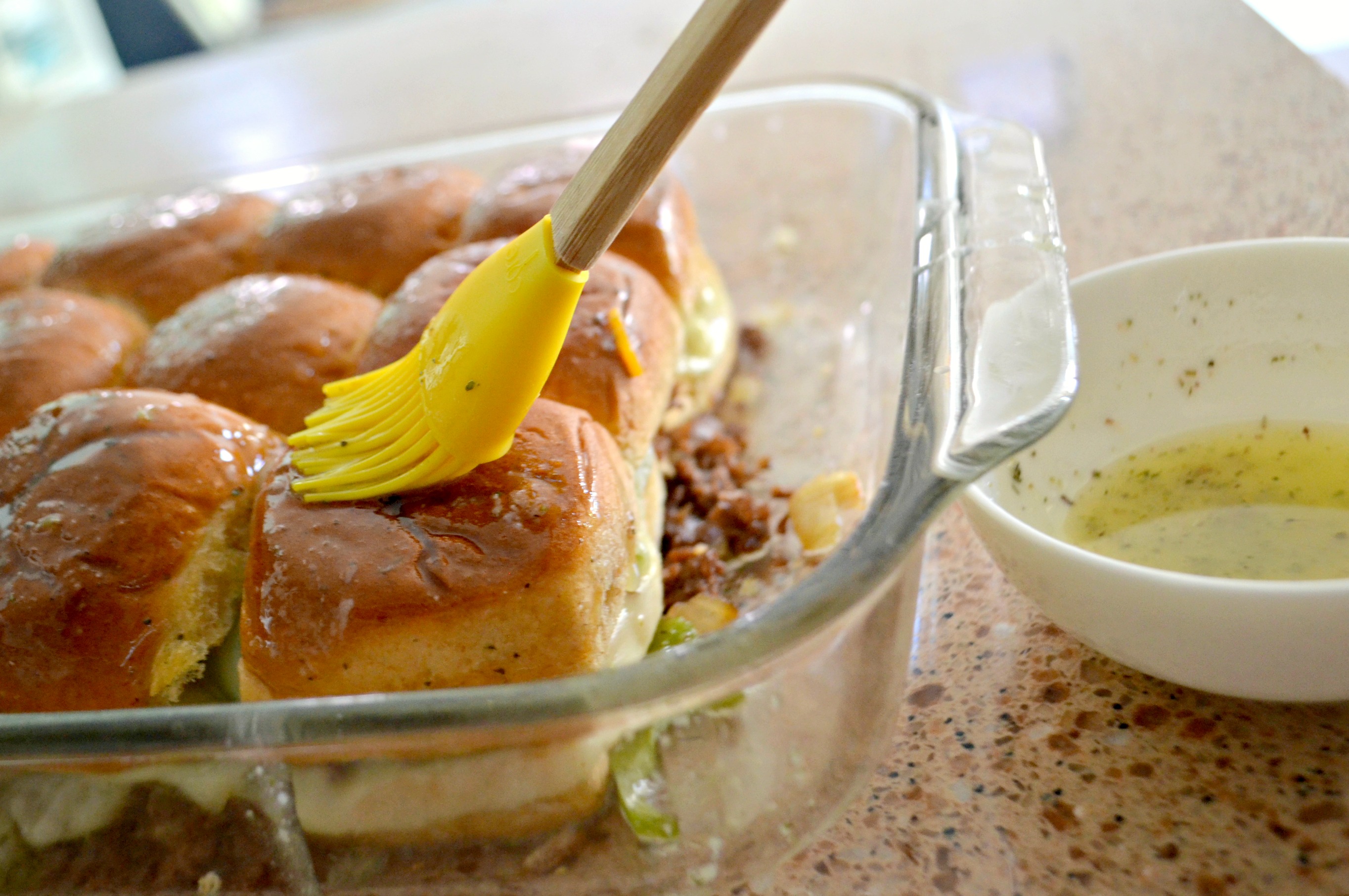 Philly Cheesesteak Sliders - brushing the tops with butter