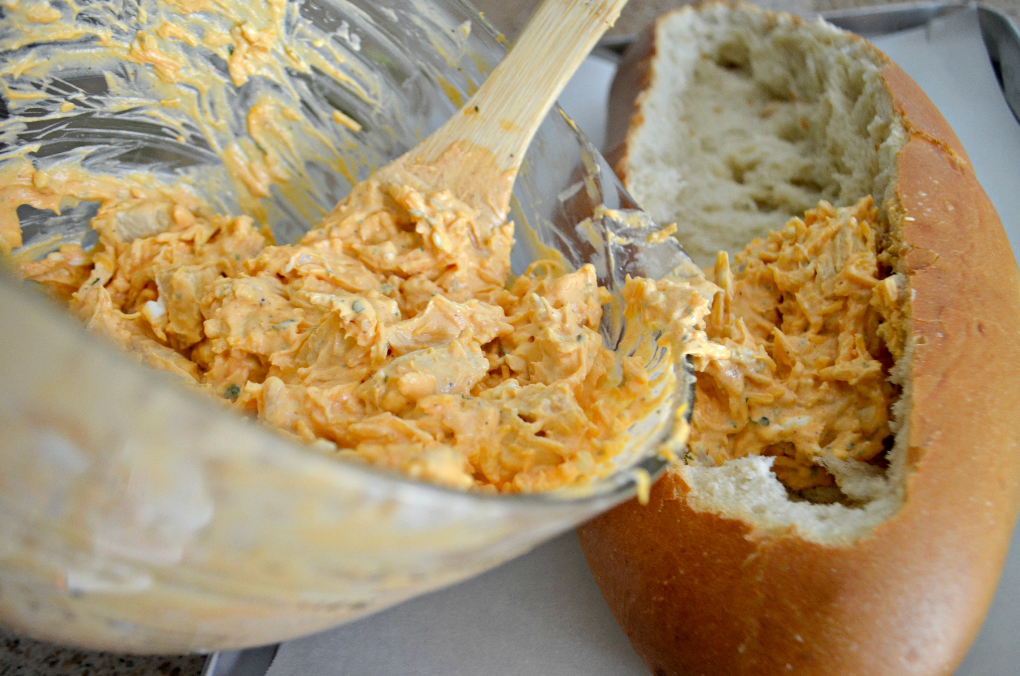 Buffalo Chicken Dip Bread Bowl - pouring the dip into the bread