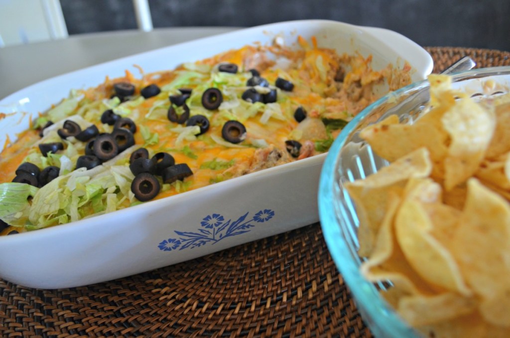 baked taco dip next to tortilla chips