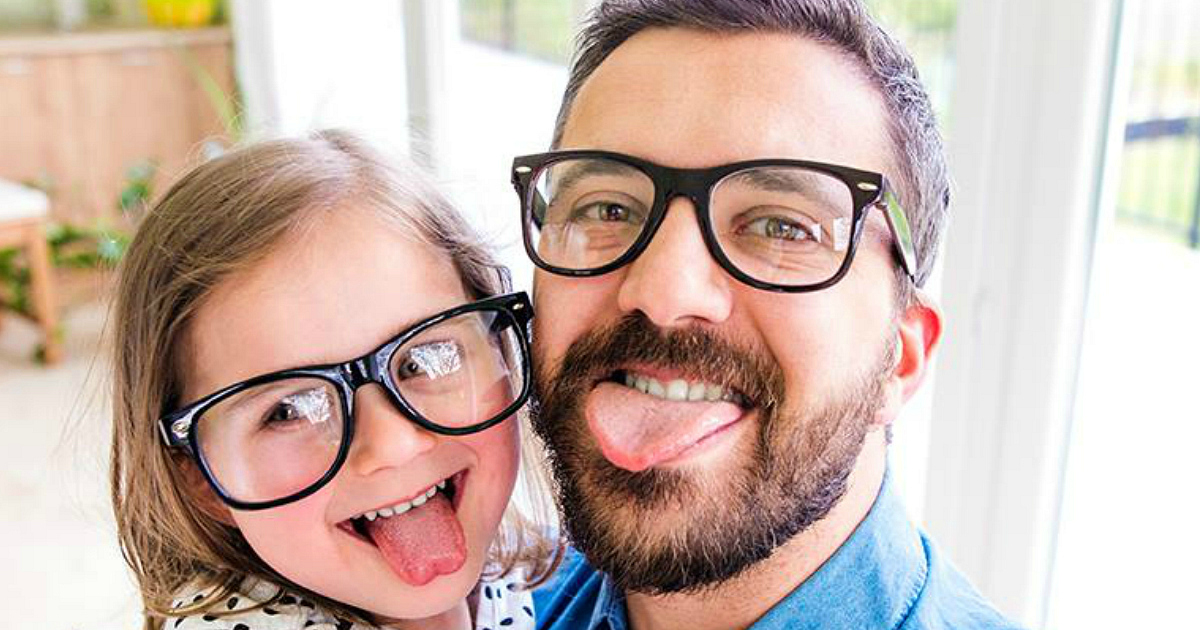 Dad and daughter sticking their tongues out for the camera