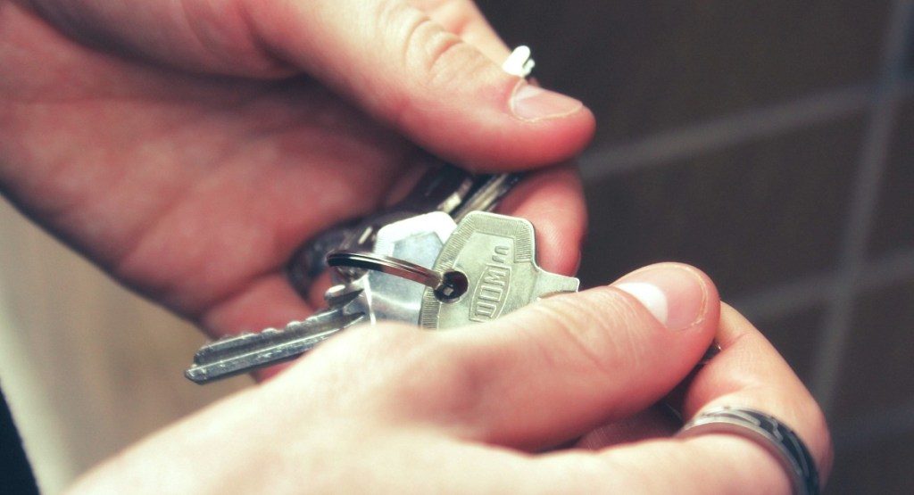 hands holding set of silver metal keys