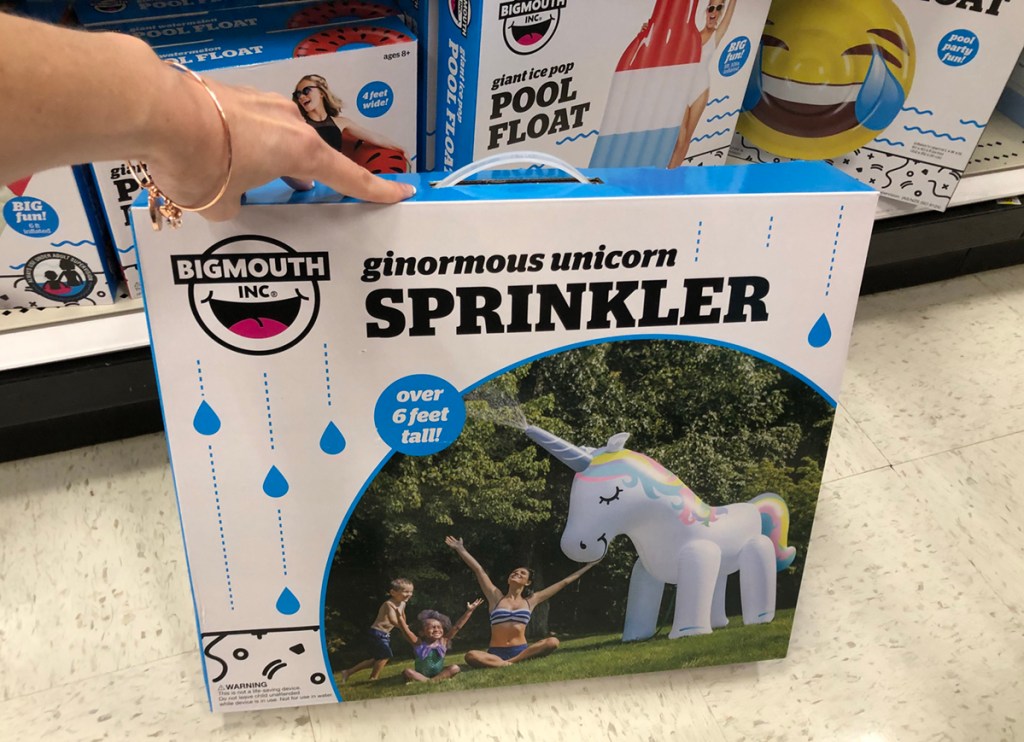 hand holding big mouth unicorn yard sprinkler