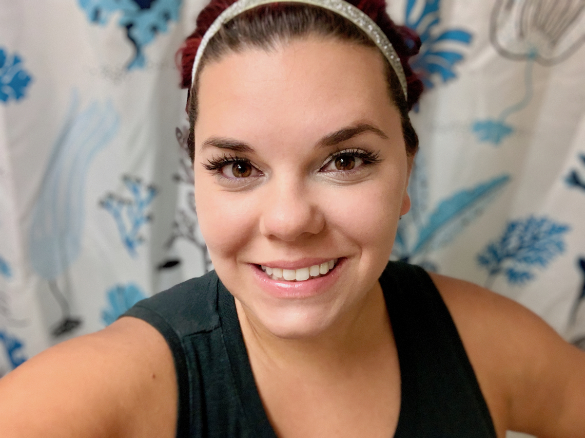 woman smiling wearing headband and false lashes