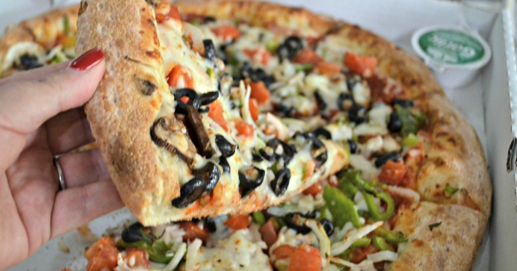 woman's hand holding slice of Papa John's pizza with various toppings