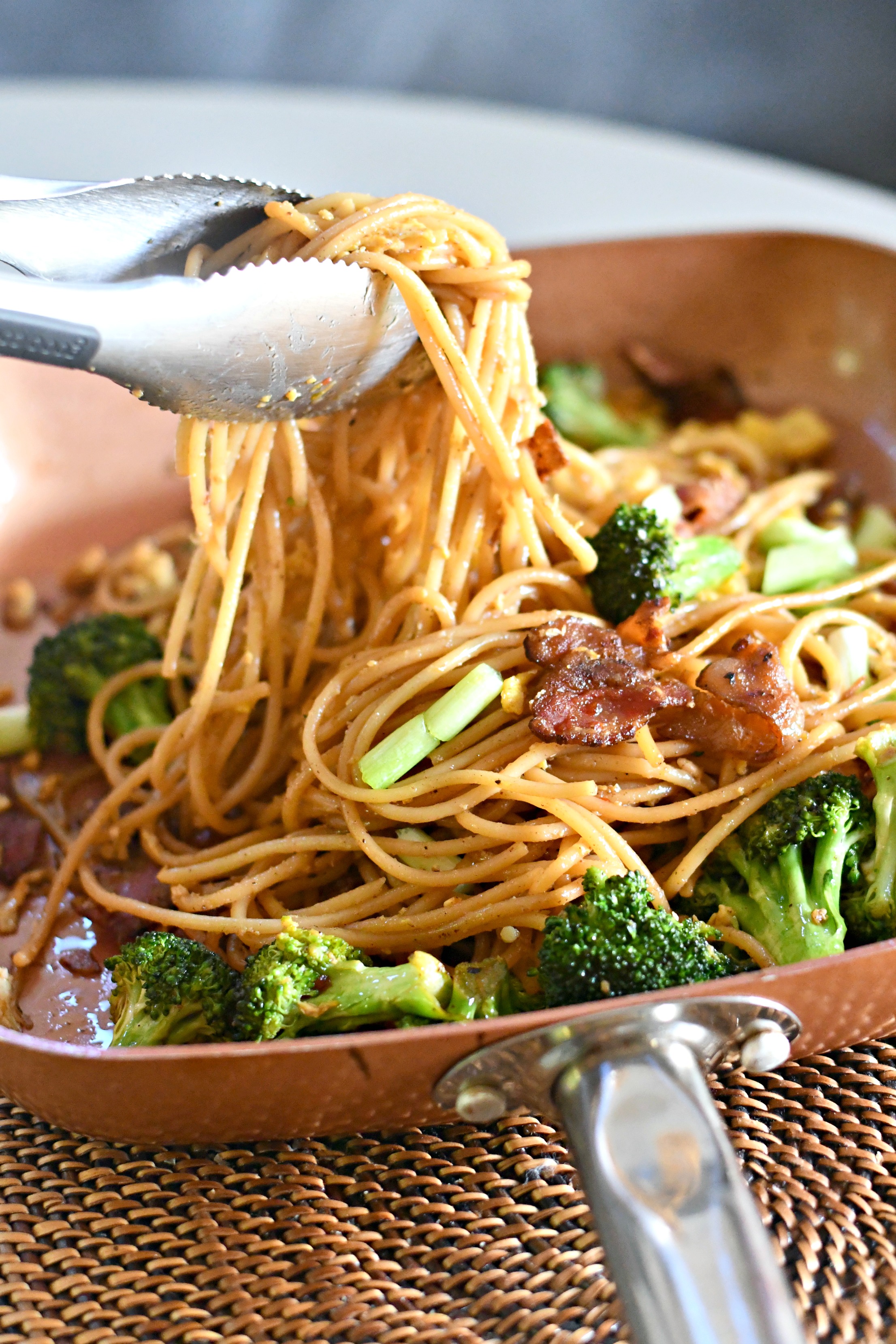 Cravings: Hungry for More Cookbook by Chrissy Teigen – noodle dish in a copper pan being served with tongs 