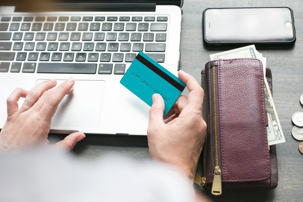 person shopping online with laptop and credit card in hand