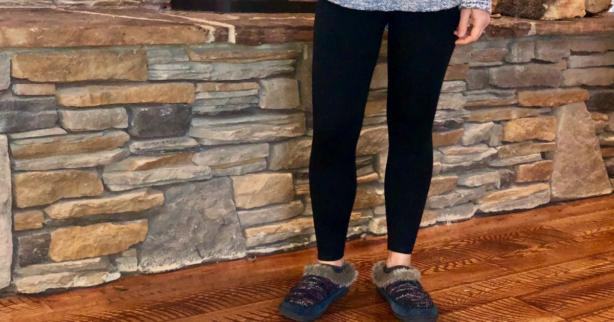 girl in front of a fireplace in black leggings