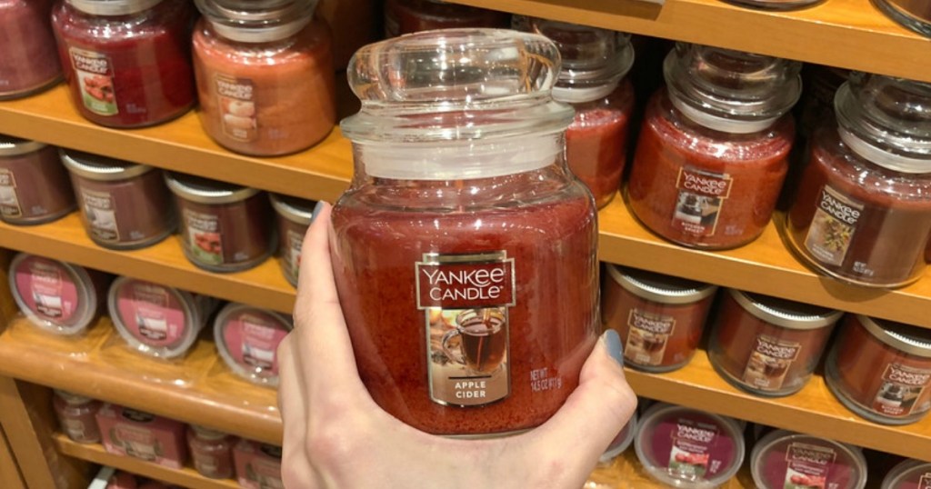 woman holding yankee medium candle