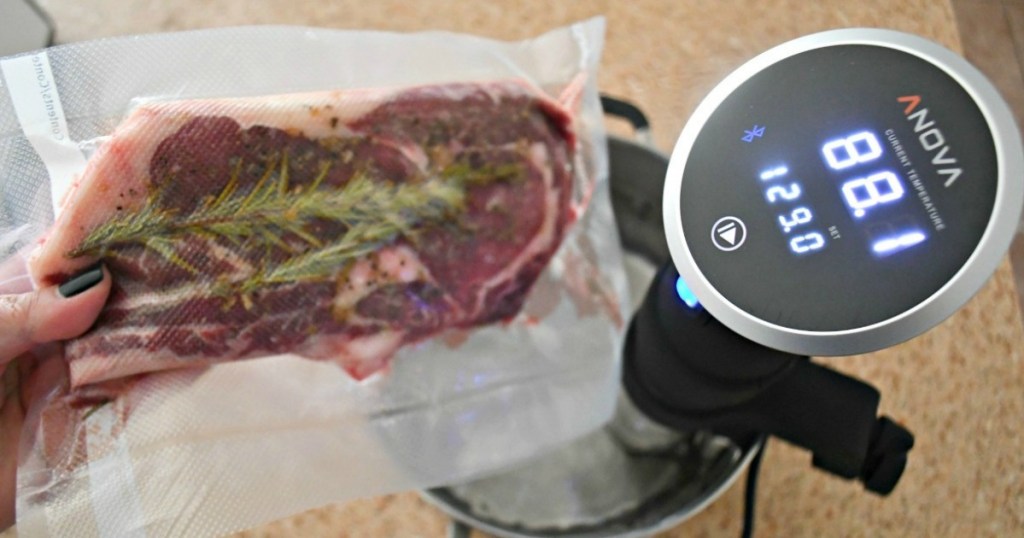 man holding steak with rosemary over anova Sous Vide immersion cooker