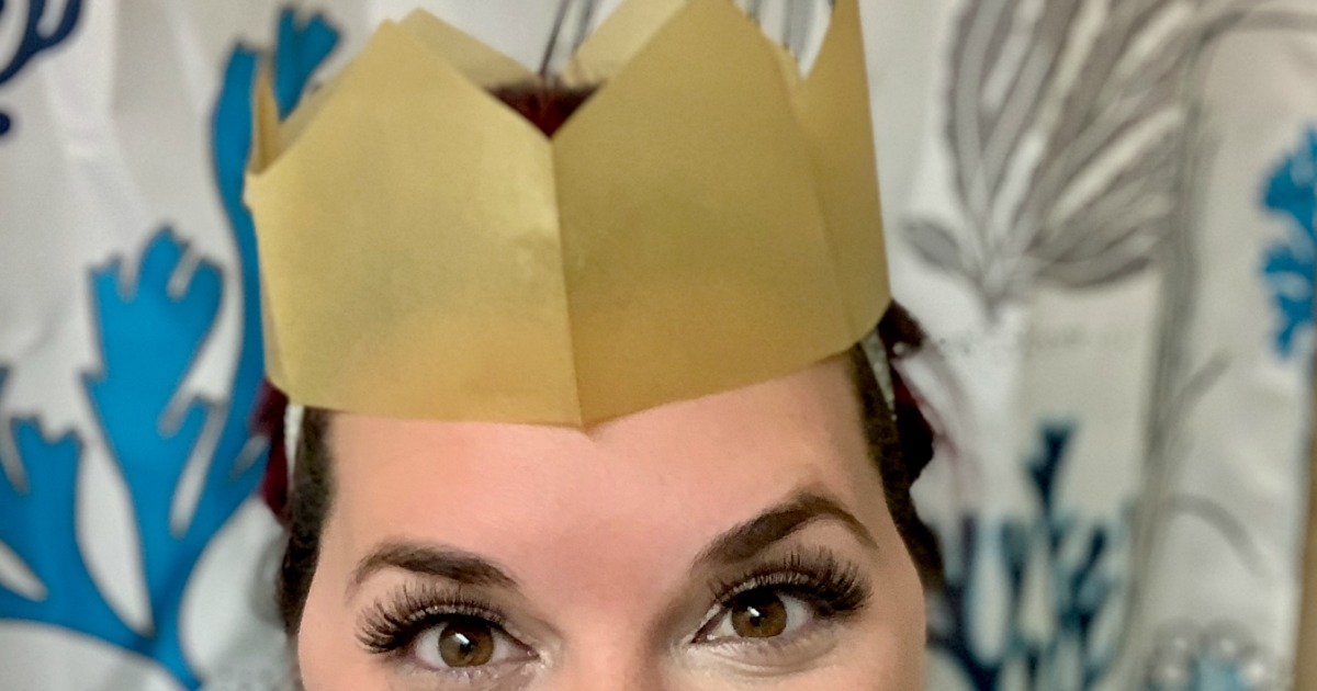 woman wearing gold paper crown and fake eyelashes