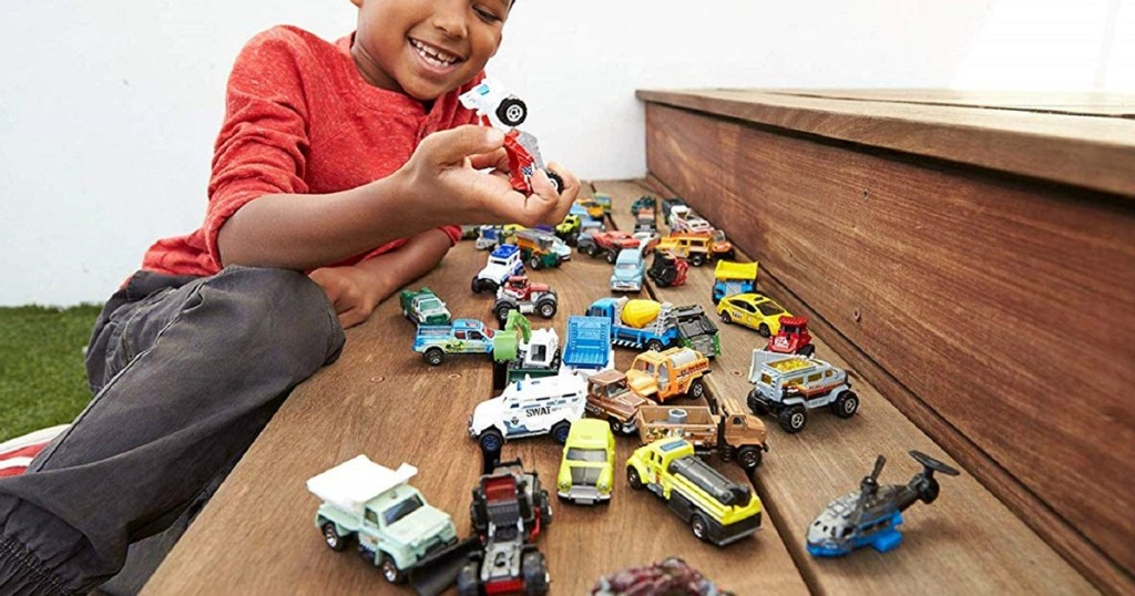 boy playing with matchbox cars on steps