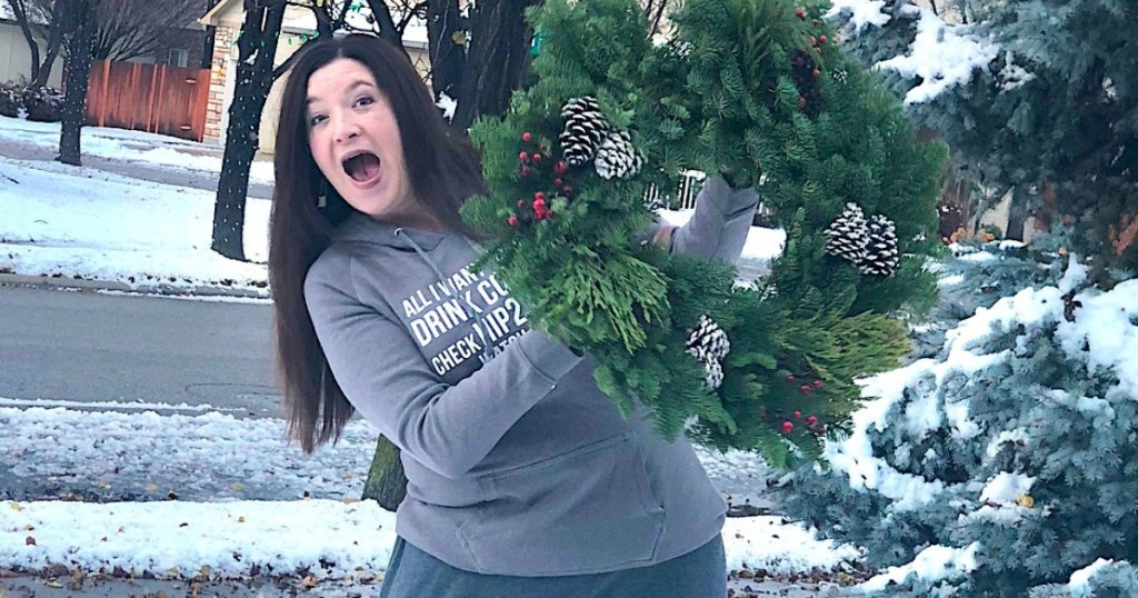 holding real Christmas wreath