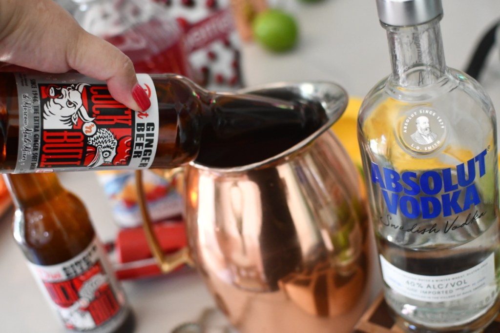 adding ginger beer to a pitcher 