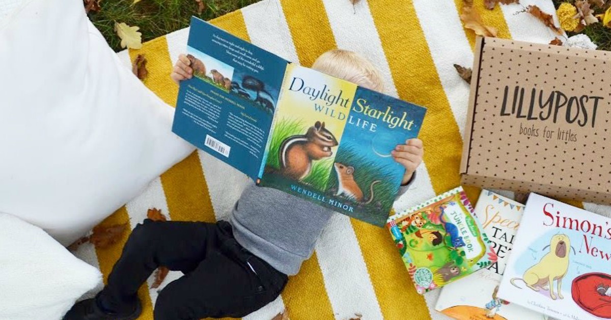 lillypost kids books subscription box promo code deal – young boy reading a book on a blanket outside