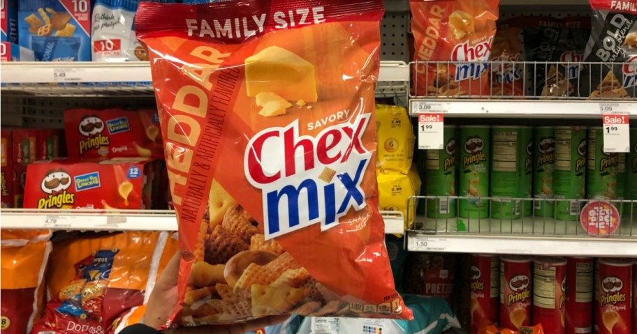 hand holding a bag of Chex mix family size 