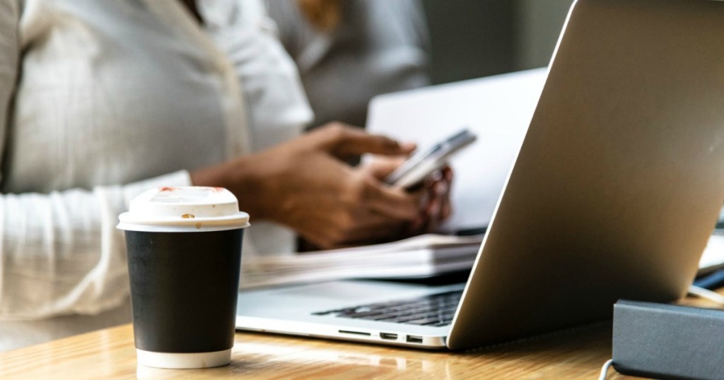 woman sitting at laptop on phone