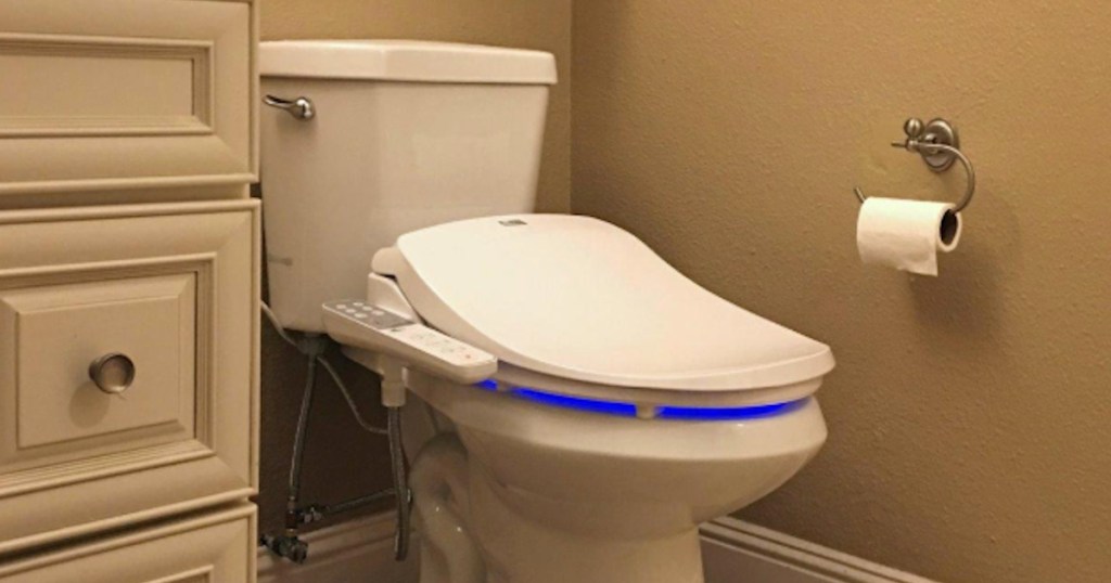 white toilet with bidet seat on top in bathroom