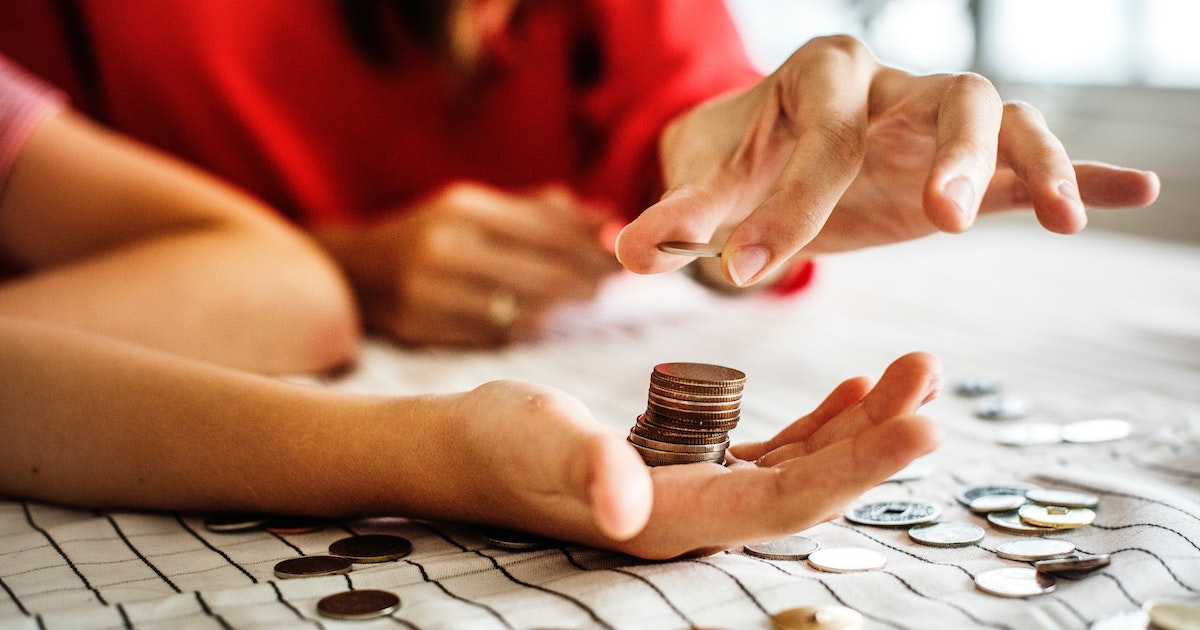  red shirt woman handing man coins money for banking money sharing