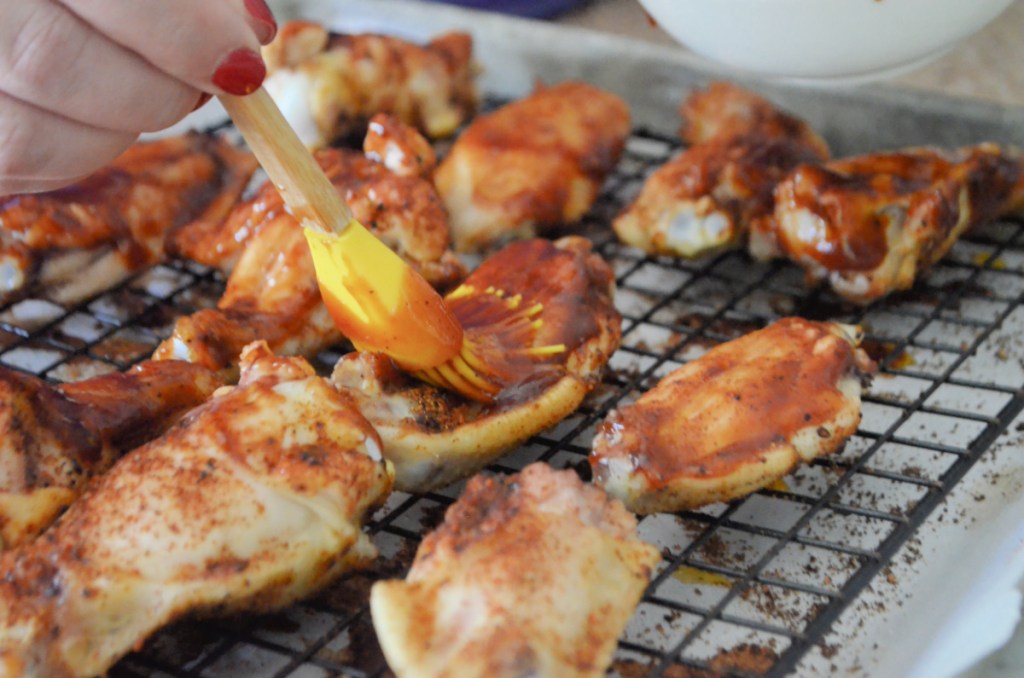 adding bbq sauce to chicken wings 