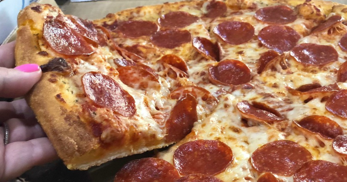 woman grabbing a slice of pepperoni pizza