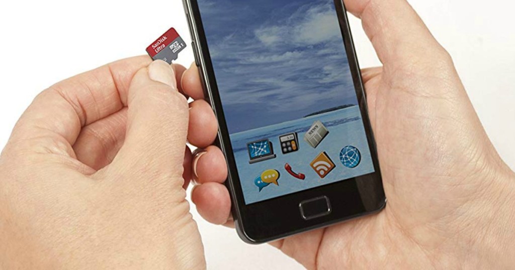 someone holding an android phone and a SanDisk card