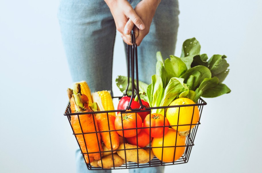 person holding a basket of vegetables