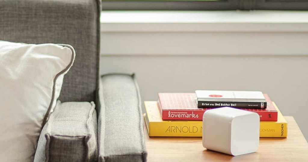 The Circle sitting on an end table with books on it as well next to a couch