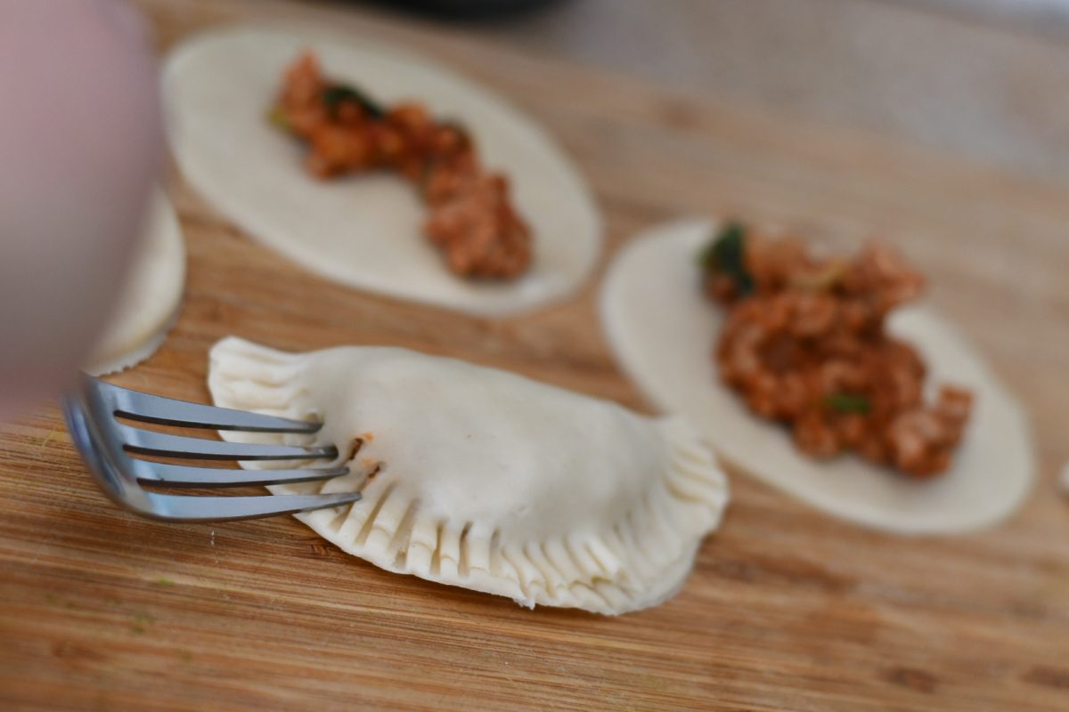 pressing the fork into the edges of the empanadas