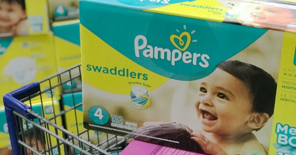 Large box of pampers swaddler sitting on top of a shopping cart