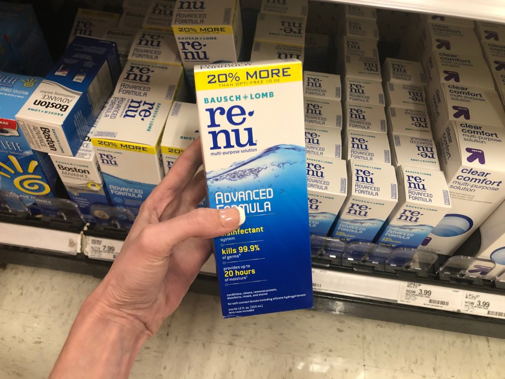 Hand holding Renu solution in front of Walgreens shelf