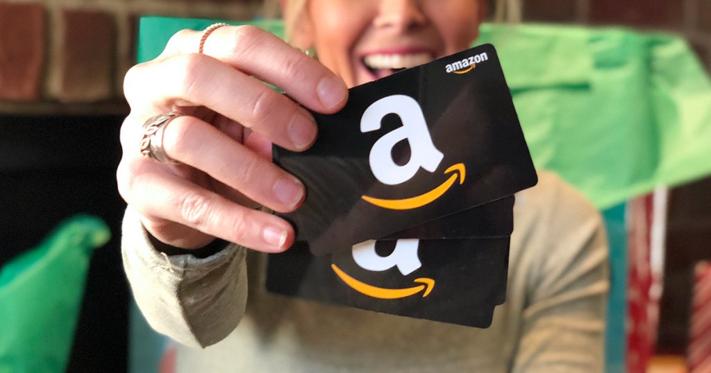 woman holding amazon two gift cards