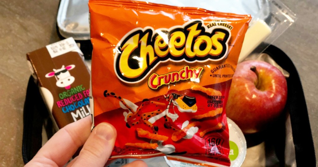 Hand holding bag of Cheetos Crunchy snack