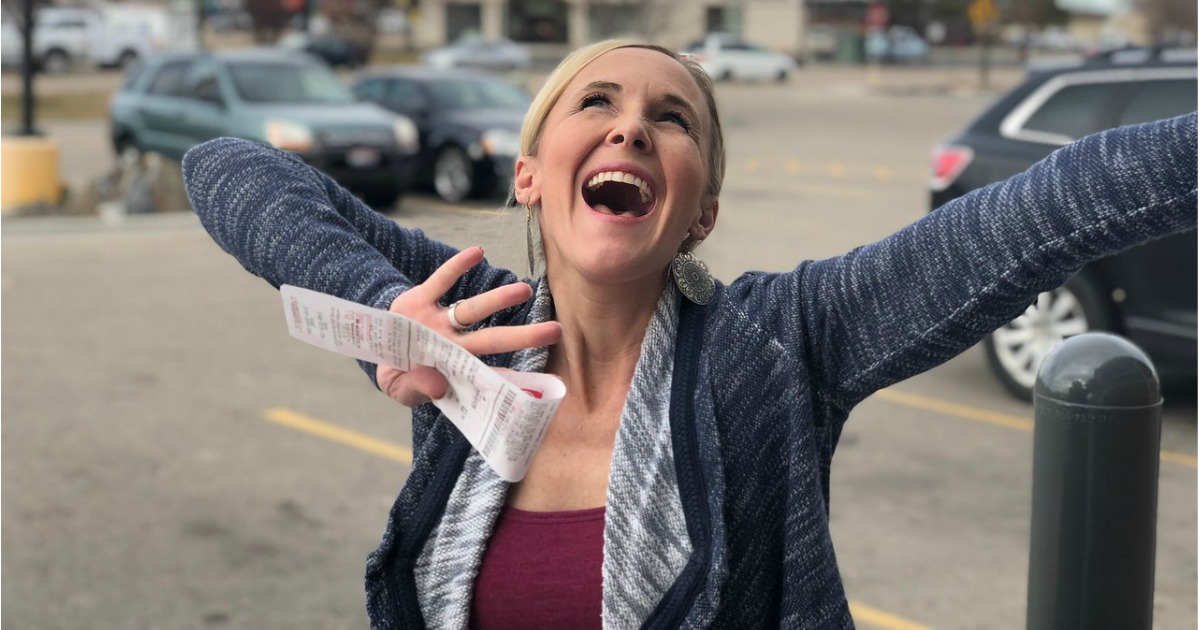 woman smiling and holding a receipt