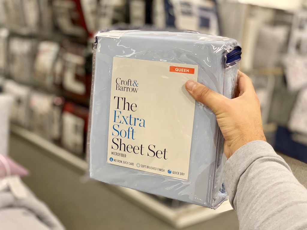 Man holding Croft & Barrow Extra Soft Sheet Set in Kohl's Store