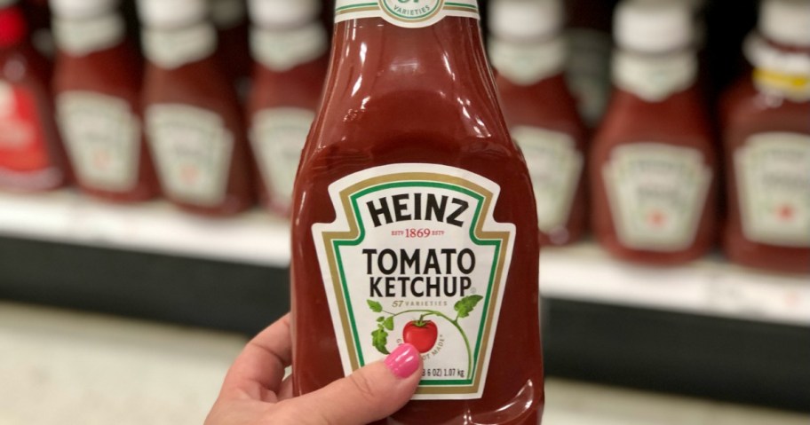 Hand holding a bottle of Heinz ketchup