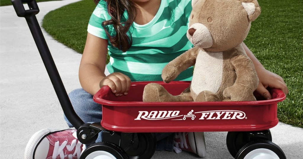 kid playing with a Radio Flyer Mini Wagon and a bear