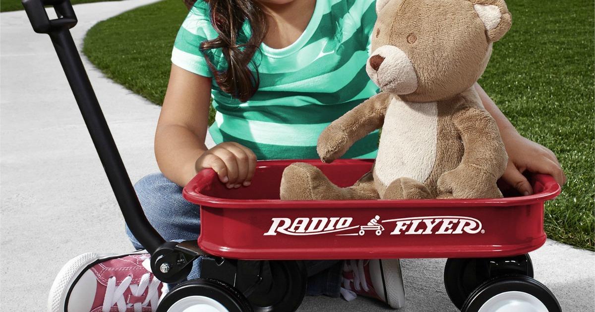 kid playing with a Radio Flyer Mini Wagon and a stuffed bear toy