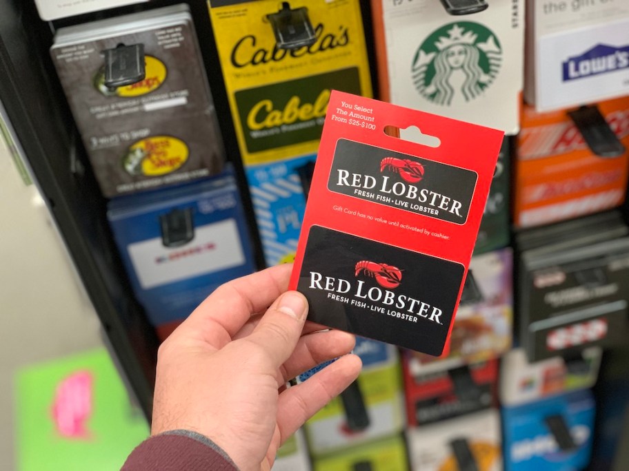 hand holding red lobster gift card in store