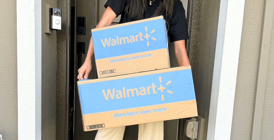 Woman holding 2 brown and blue walmart shipping boxes