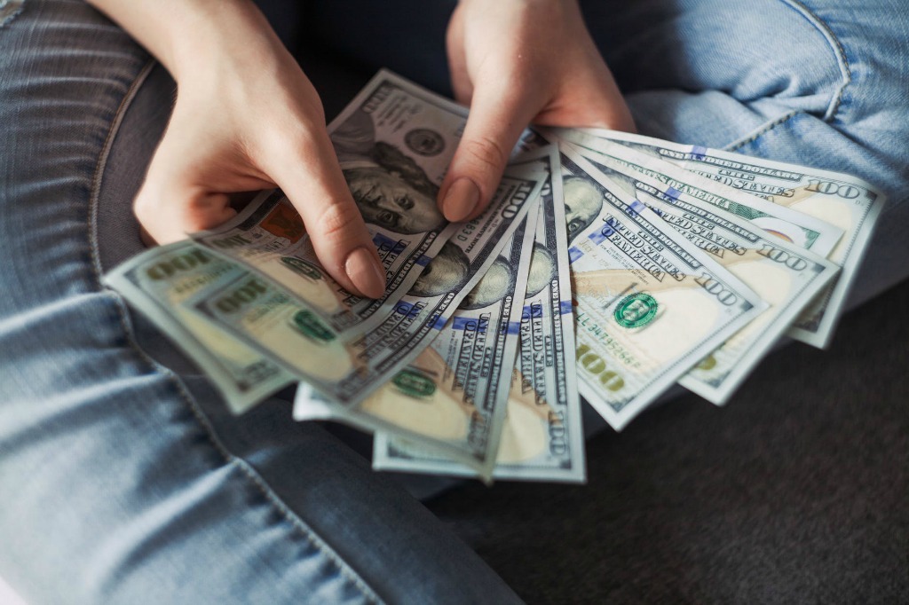 woman holding a fan of cash