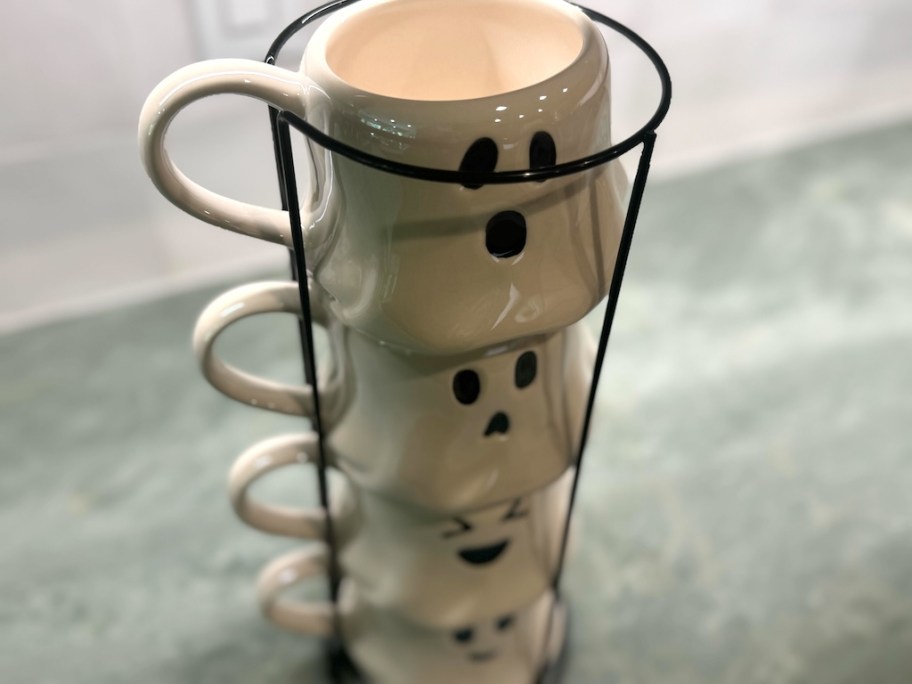 close up of ghost stacking mugs on green countertop