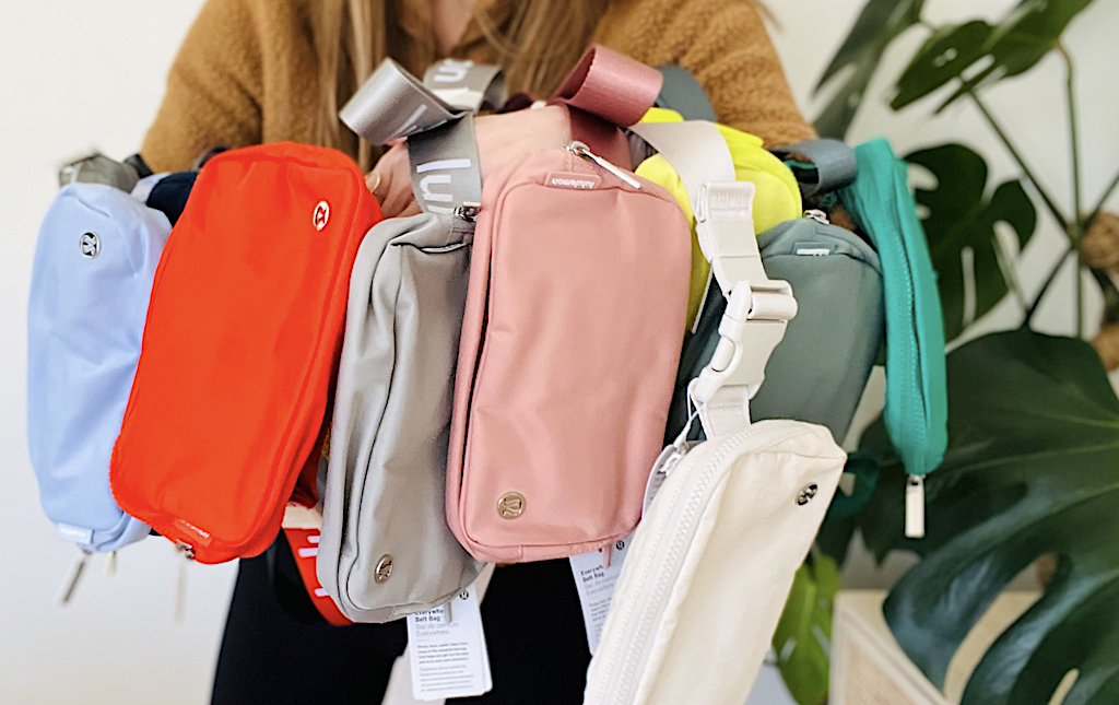 holding different colored belt bags