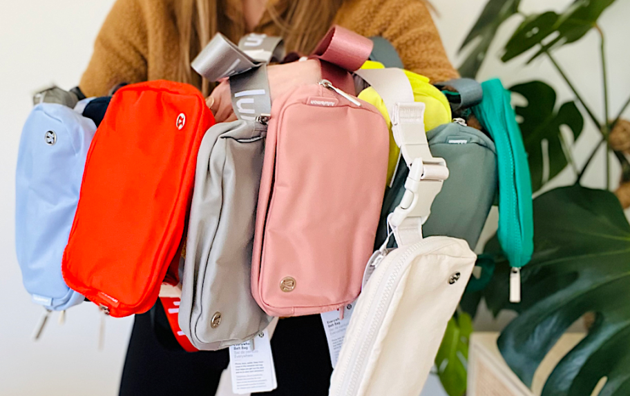 holding different colored belt bags