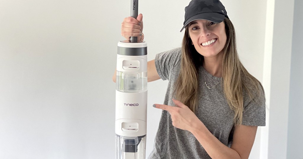 woman with black baseball hat holding up tineco mop