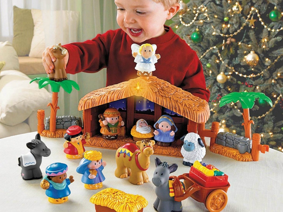 little boy playing with toy nativity set