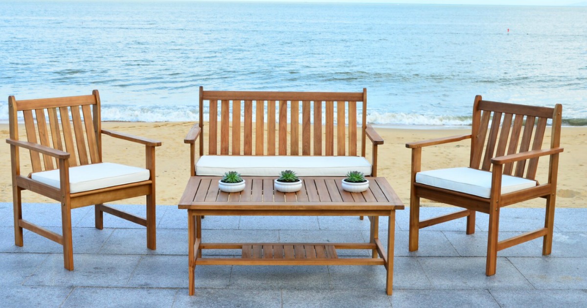 wooden outdoor patio set with chairs, table and sofa on a beach