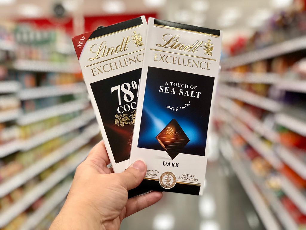 hand holding 2 chocolate bars on aisle