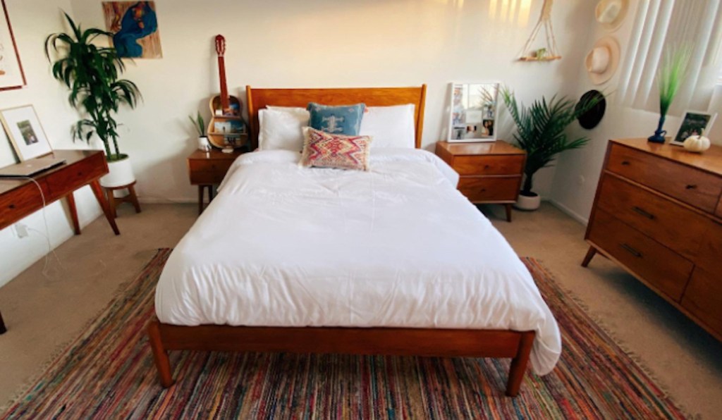 bedroom with white duvet cover on bed and various boho decor